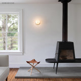 Glass globe wall lamp in a living room beside a wood burning stove