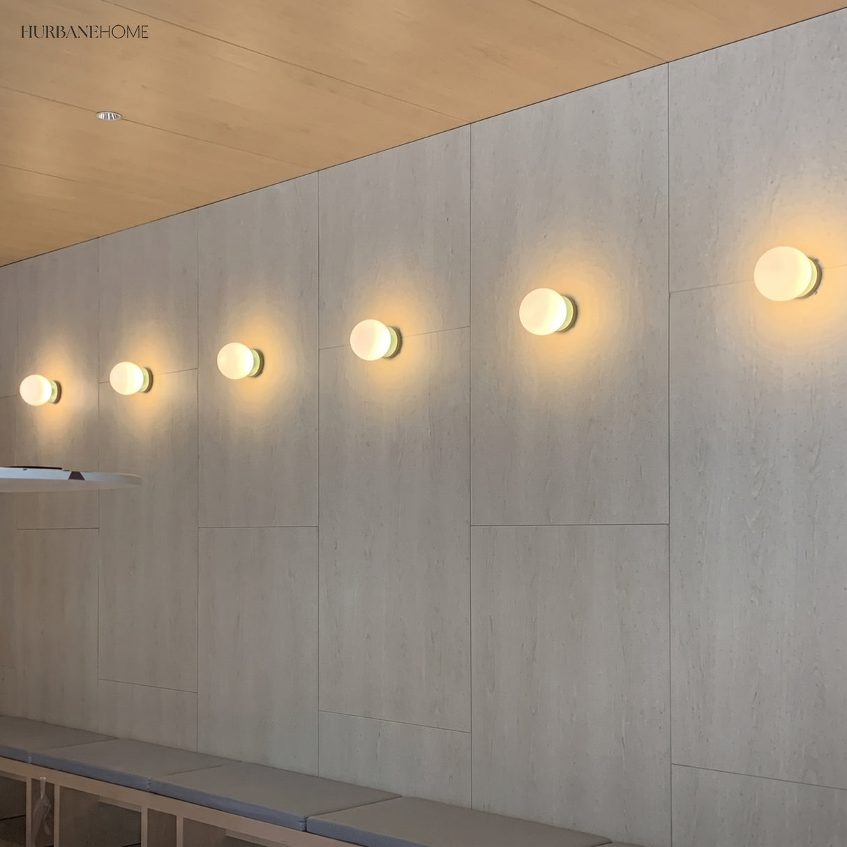 Row of glass globe wall lamps along a corridor wall