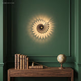 Nautilus shell wall light on a green wall above a console