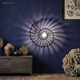 Nautilus shell wall light on a purple wall with decor
