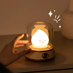 Fingertips reaching toward the clear dome of the lit flame night light