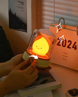 Hand adjusting the knob of the night light on a desk in front of a calendar
