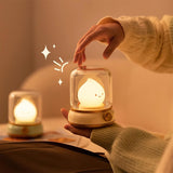 One night light held in a hand beside a second one resting on a book