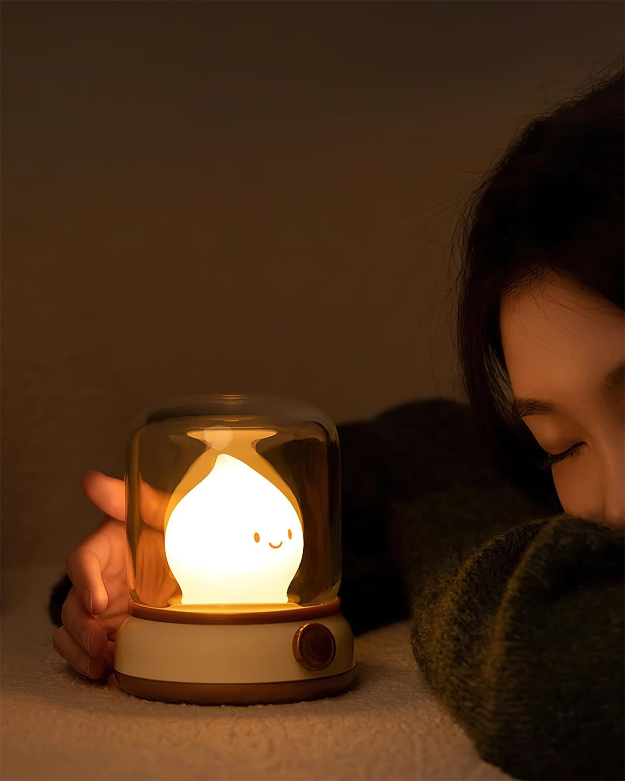 Child asleep with one hand resting against the glowing flame night light