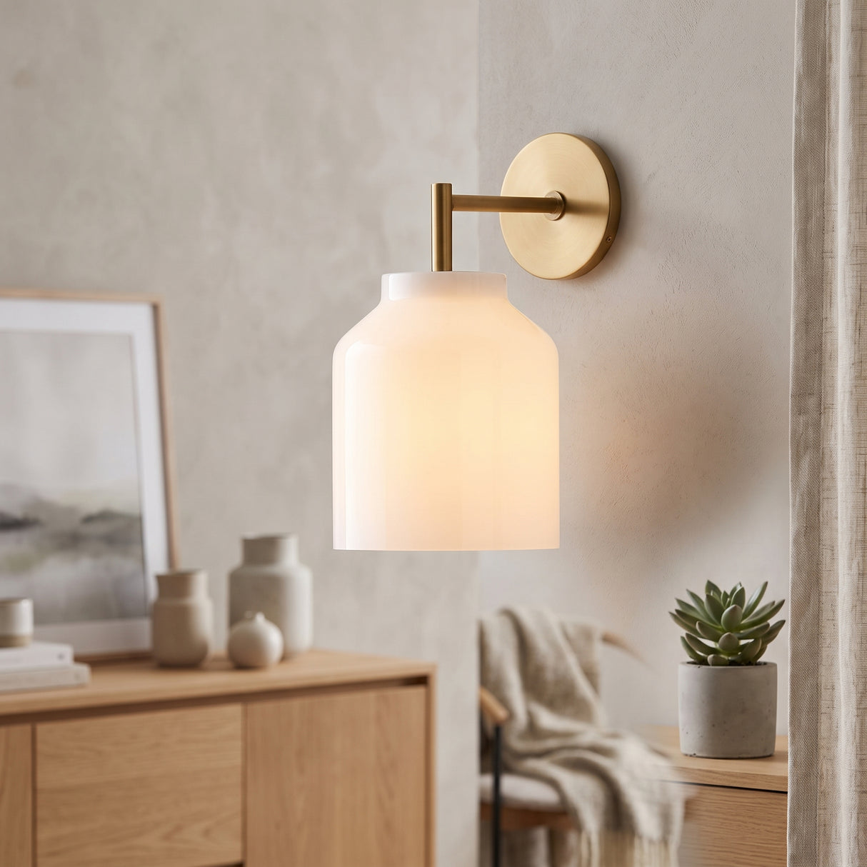Brass arm wall sconce with milk glass dome shade above an oak sideboard