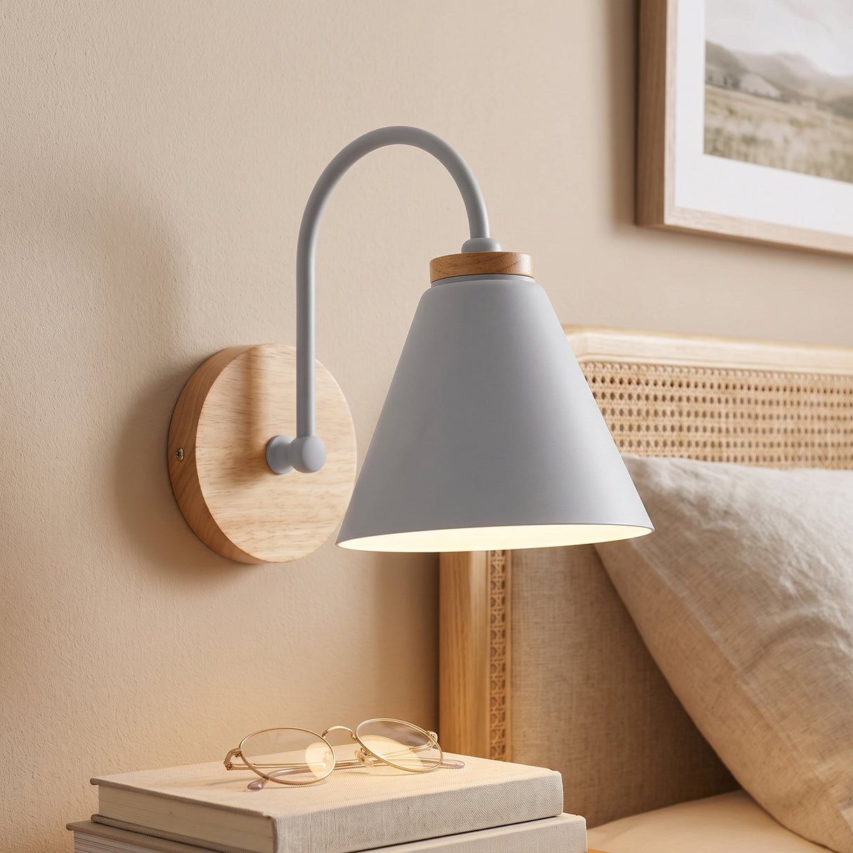 Grey cone shade sconce on a wood mount lit above a bed