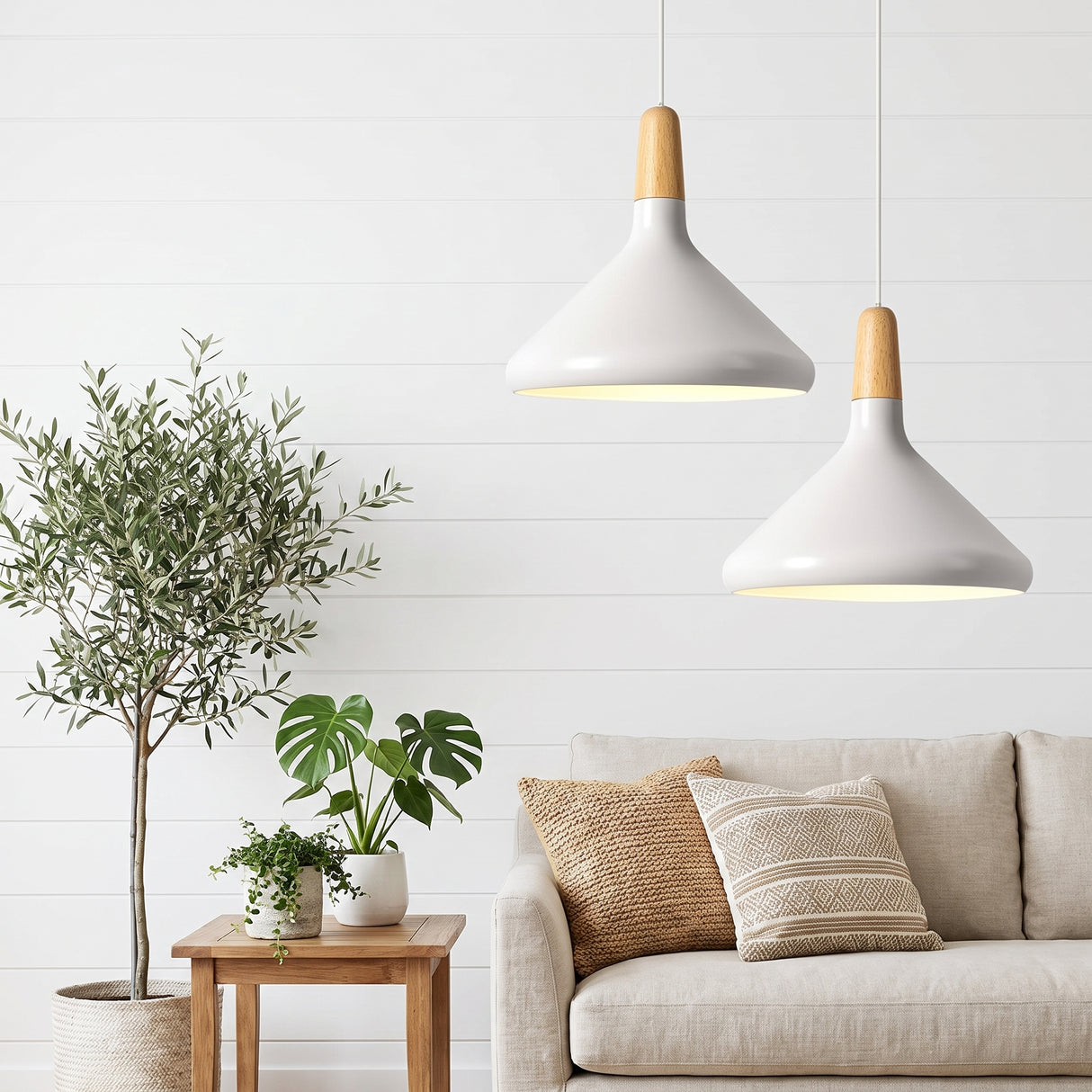 Pair of white pendants with wood tops above a sofa and an olive tree