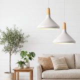 Pair of white pendants with wood tops above a sofa and an olive tree