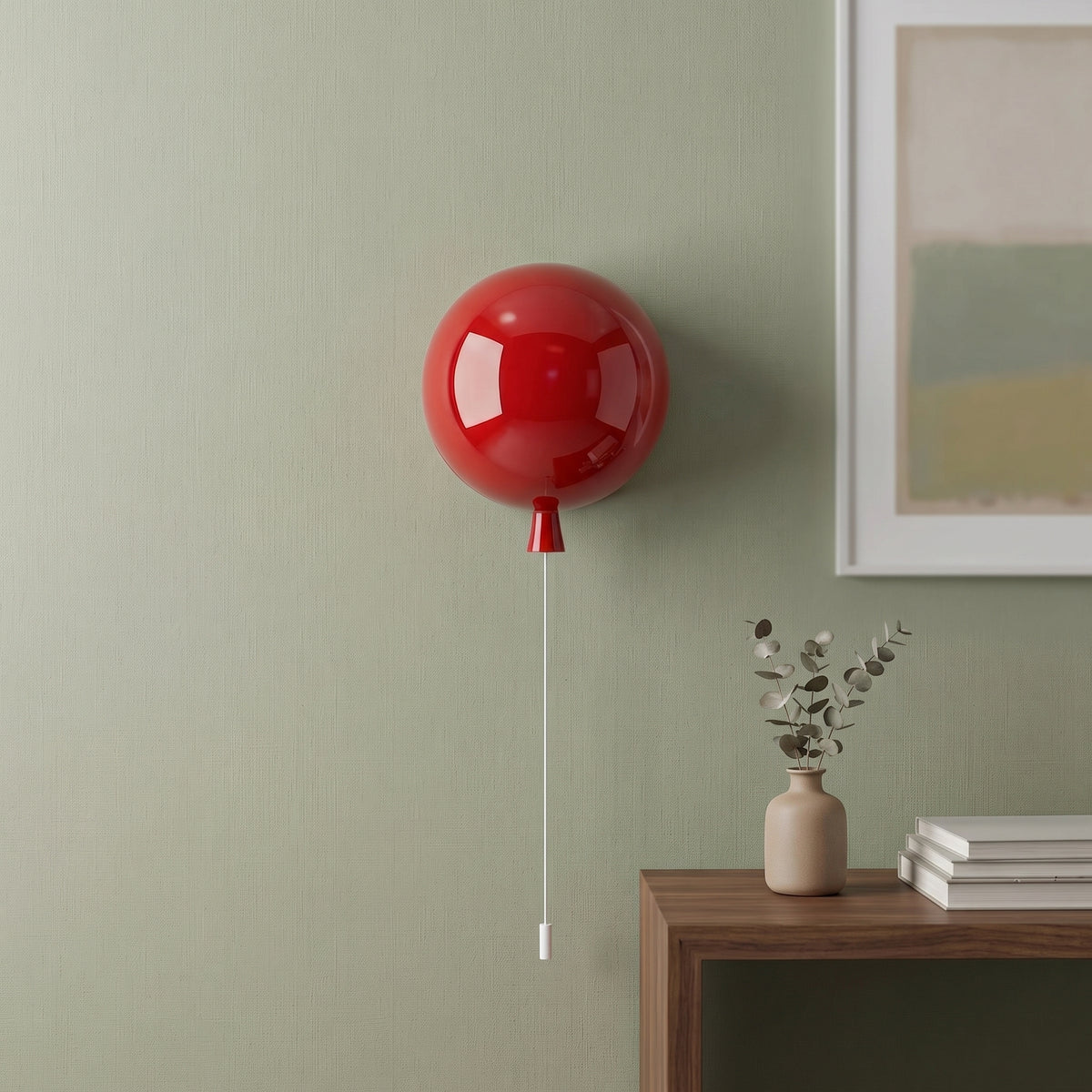 Red balloon light mounted on a green wall above a console