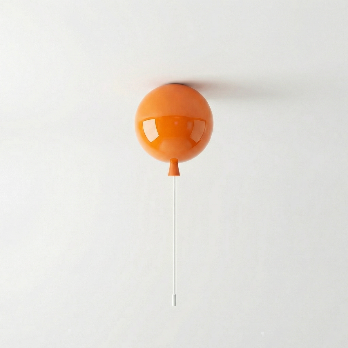 Orange balloon light fitted to a ceiling above a plain wall