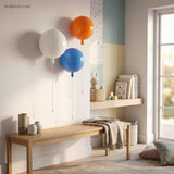 Four balloon lights in white, orange and blue on a playroom wall