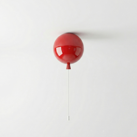 Red balloon light lit on a white wall with a hanging pull cord