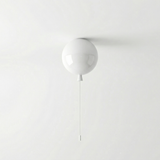 White balloon light fitted to a ceiling above a plain grey wall
