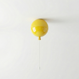 Yellow balloon light mounted on a ceiling with its cord hanging