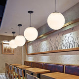 White glass globe shade on a slim metal suspension