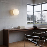 Opal glass wall sconce on concrete wall in a Bauhaus style study