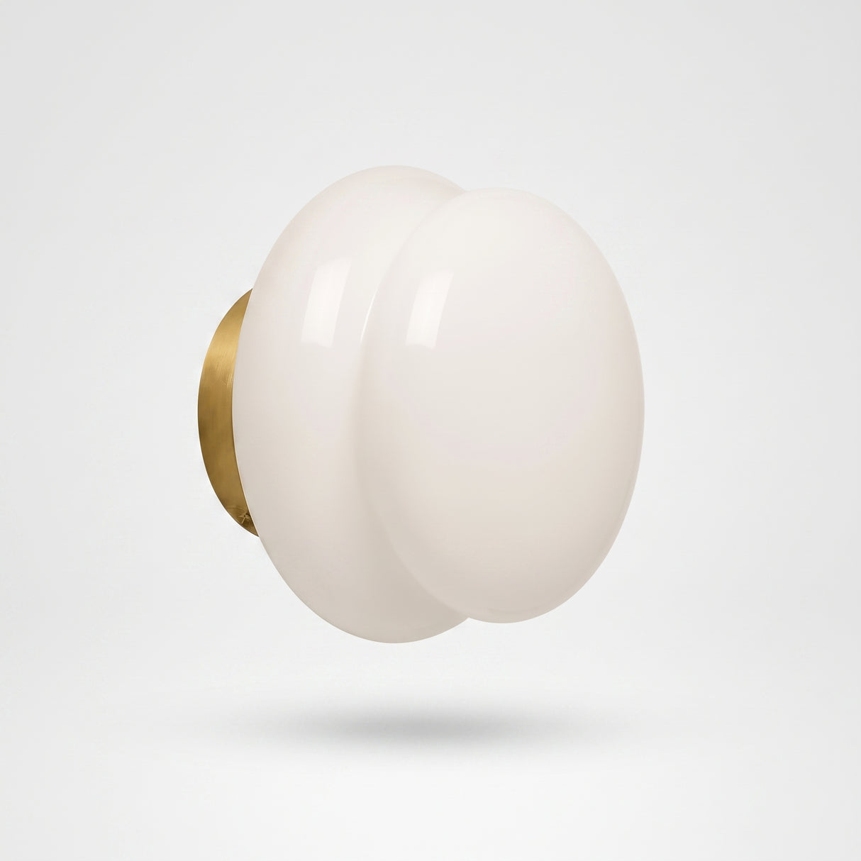 White opal glass wall sconce on a brushed brass round backplate