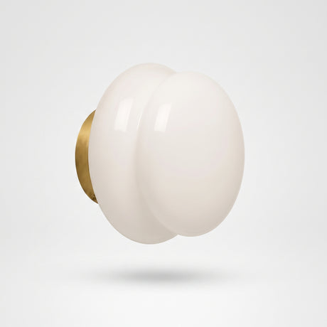 White opal glass wall sconce on a brushed brass round backplate