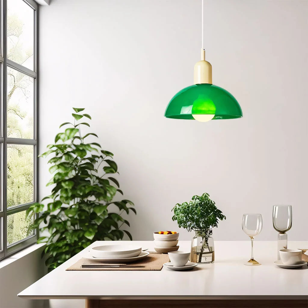 Orange glass bowl pendant light viewed from the side on a plain background