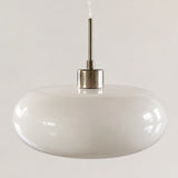 Orange oval glass pendant shade shown against a plain studio background