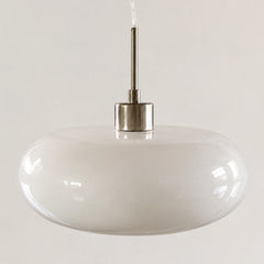 Orange oval glass pendant shade shown against a plain studio background