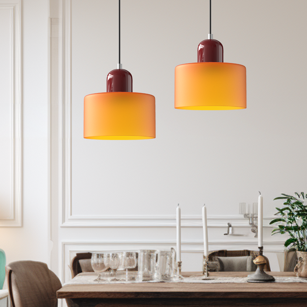 Two orange glass pendant lights above a dining table with panelled walls