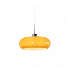 Orange glass pendant light on a thin cord photographed on a white background