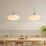 Orange glass pendant light over a wooden desk styled as a study nook