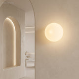 Frosted glass orb wall sconce in a styled interior