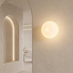 Frosted glass orb wall sconce in a styled interior