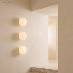 Frosted glass orb wall sconces in a styled interior
