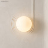 Frosted glass orb wall sconce in a styled interior