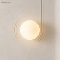 Frosted glass orb wall sconce in a styled interior