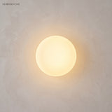 Frosted glass orb wall sconce in a styled interior