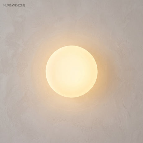 Frosted glass orb wall sconce in a styled interior