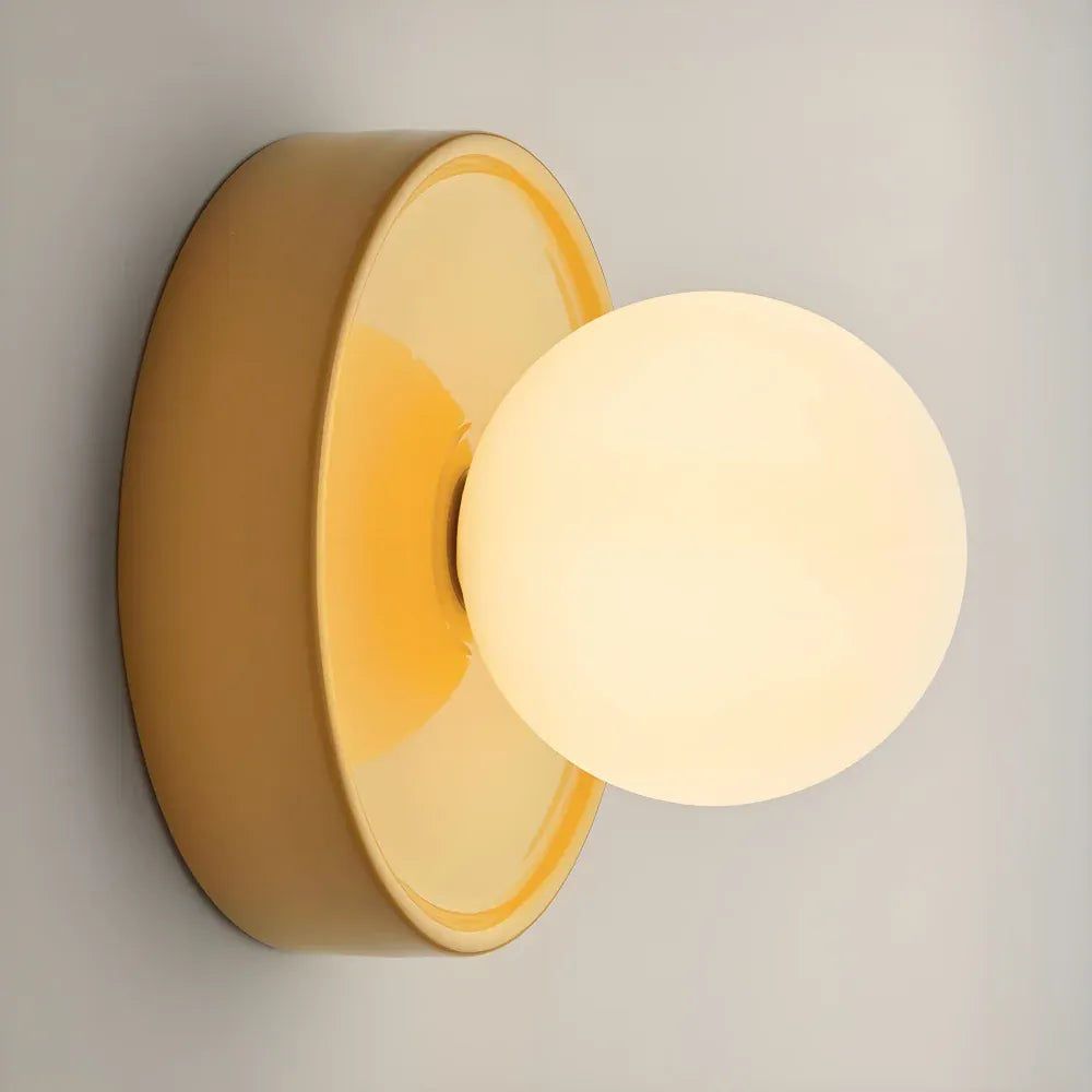 Orb wall sconce lit up showing the warm glow through the frosted globe