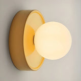 Orb wall sconce lit up showing the warm glow through the frosted globe