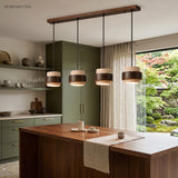 Travertine pendant light with wood band over a kitchen island