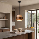 Single travertine cylinder pendant light in a minimalist room
