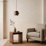 Travertine pendant light with wood band over a side table and armchair