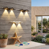Two starfish lights casting rays across a pale courtyard wall