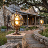 Globe post light on a stone pier beside a gravel driveway