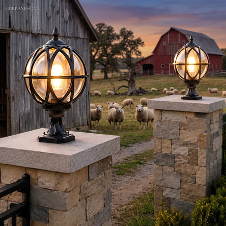 Caged globe lanterns lighting stone piers at a garden entrance