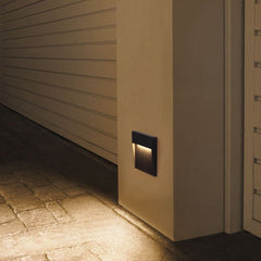 Step light on cream cladding lighting a stone paved doorway