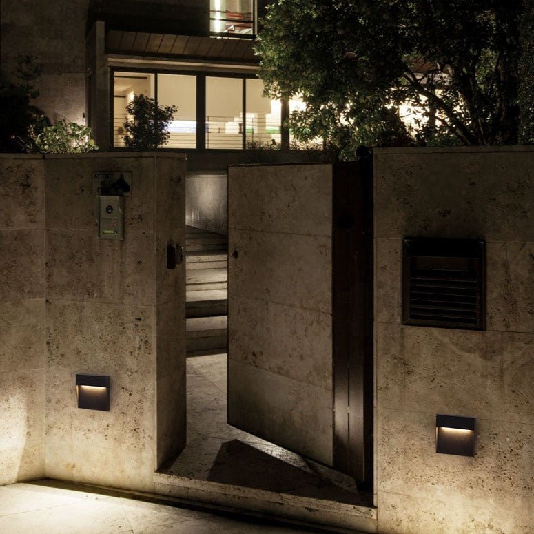 Two step lights lighting a stone entrance and a vented wall panel