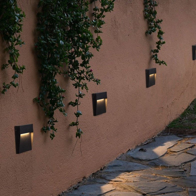 Step lights on a curved terracotta wall with trailing ivy above