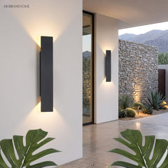 Two black LED outdoor wall lights casting up and down glow on entryway wall