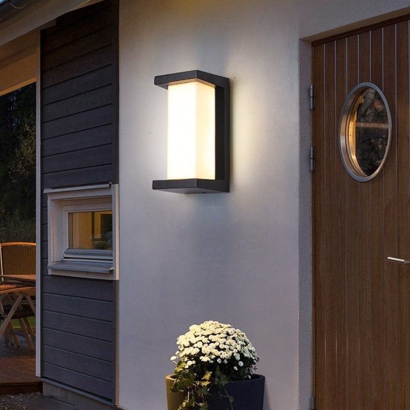 Outdoor lantern lit beside a wooden front door and window