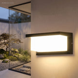 Wide outdoor wall light throwing light across a rendered garden wall