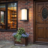 Outdoor lantern glowing on red brick beside a panelled front door